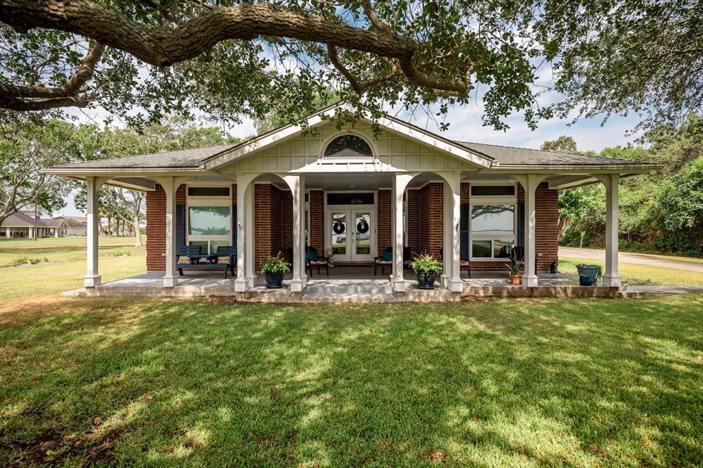 front view of a house with a big yard and large trees