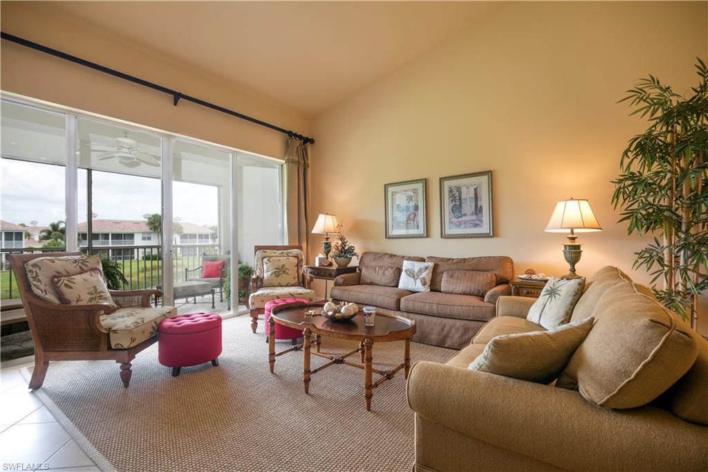 a living room with furniture and a floor to ceiling window