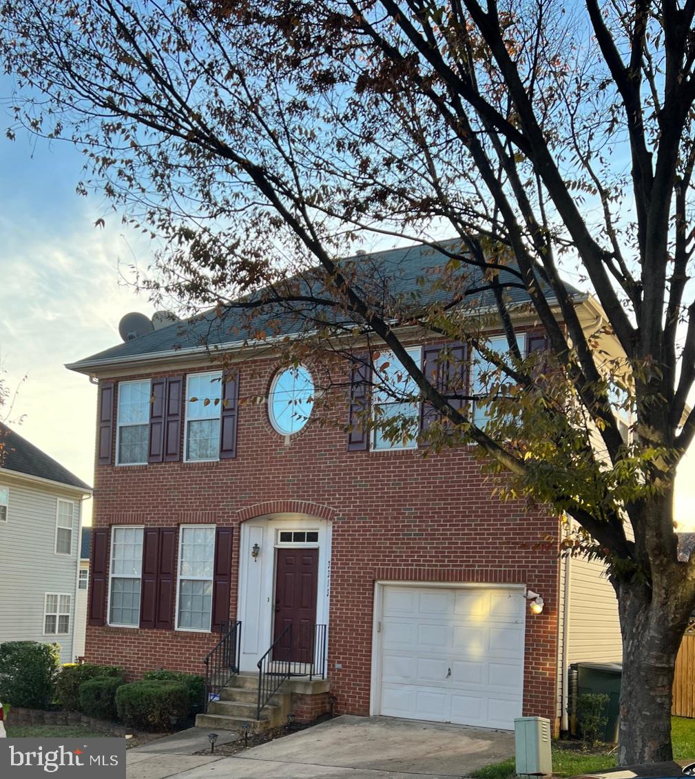 a front view of a house with a tree