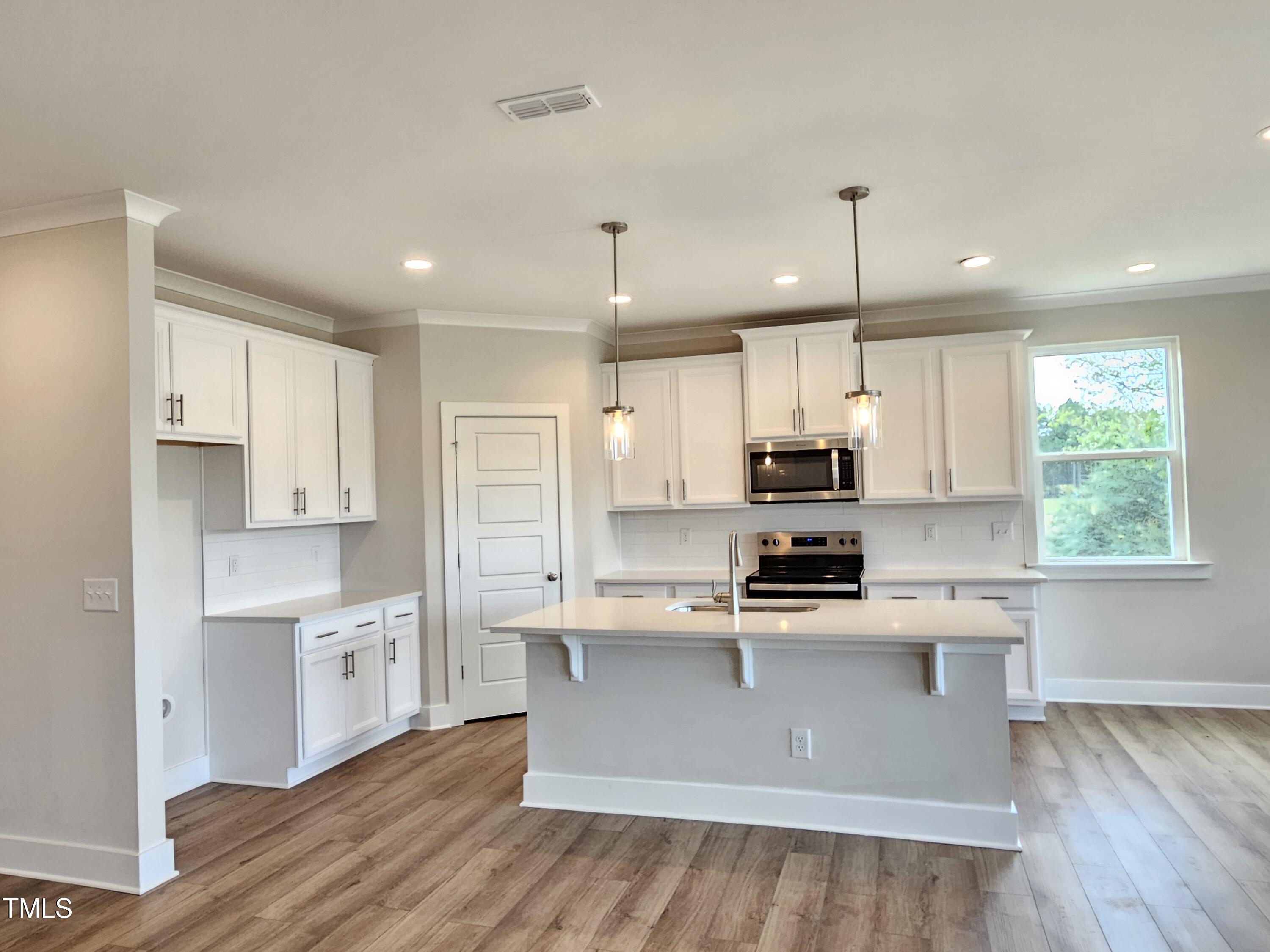 a kitchen with kitchen island a sink stainless steel appliances and cabinets