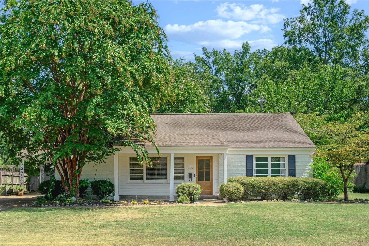 Single story home featuring a front yard, new wood door