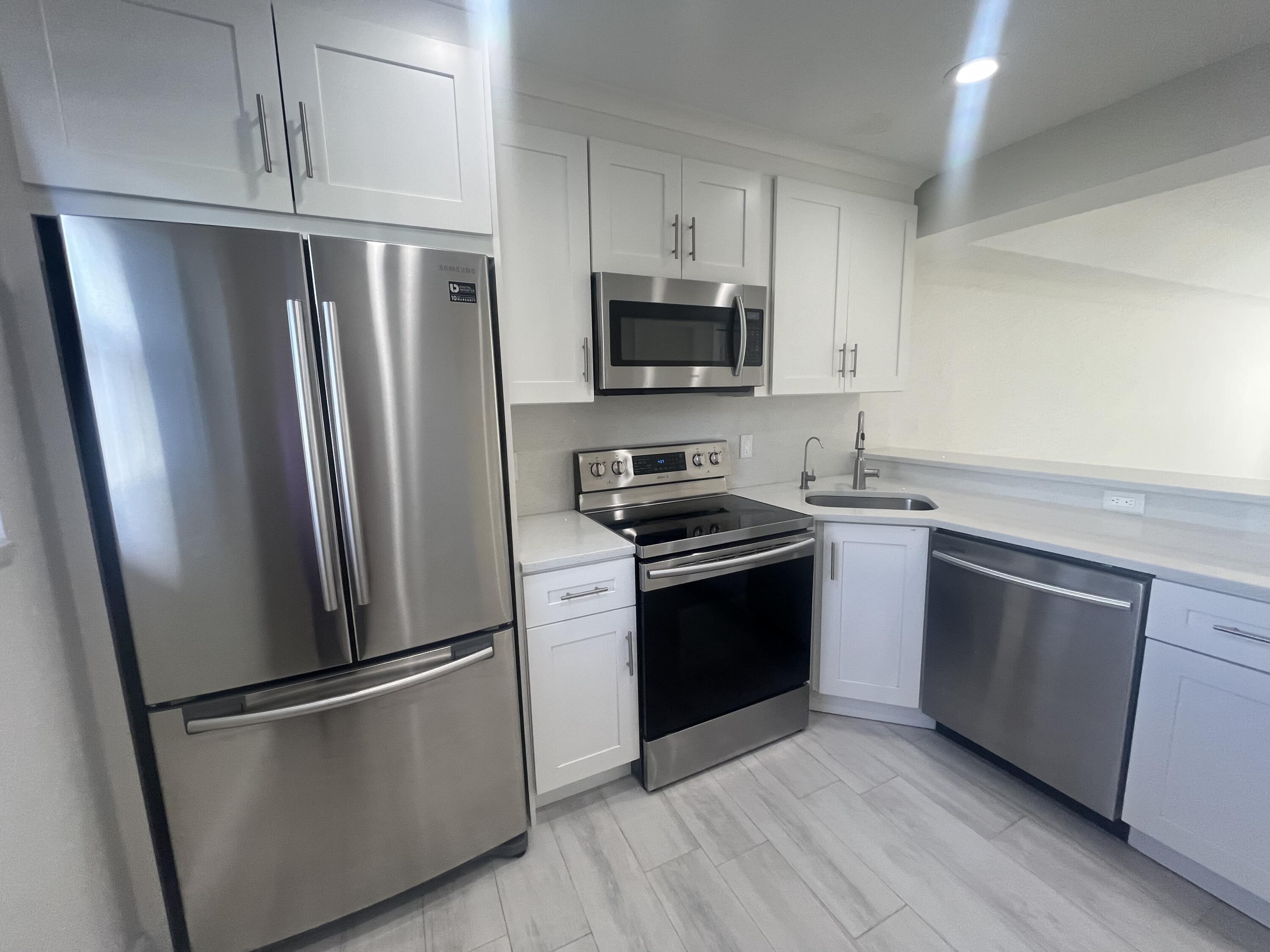 a kitchen with stainless steel appliances a refrigerator stove and microwave