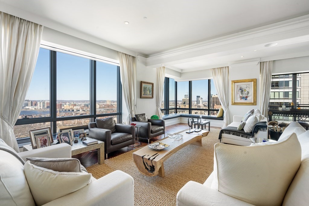 a living room with furniture and floor to ceiling windows