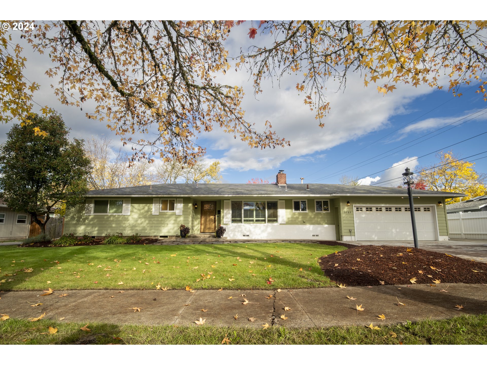 a view of an house with backyard and tree s