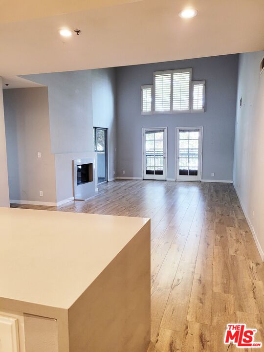 a view of an empty room with window and wooden floor