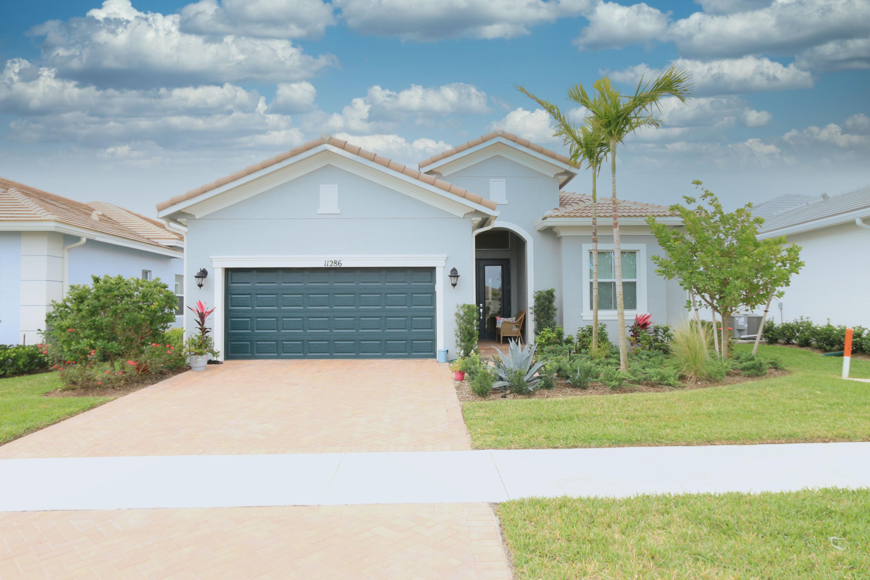 a front view of a house with a yard and garage