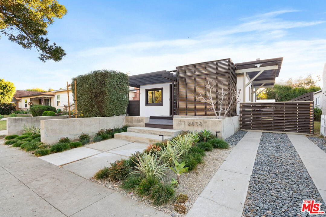 a view of a house with a small yard and plants