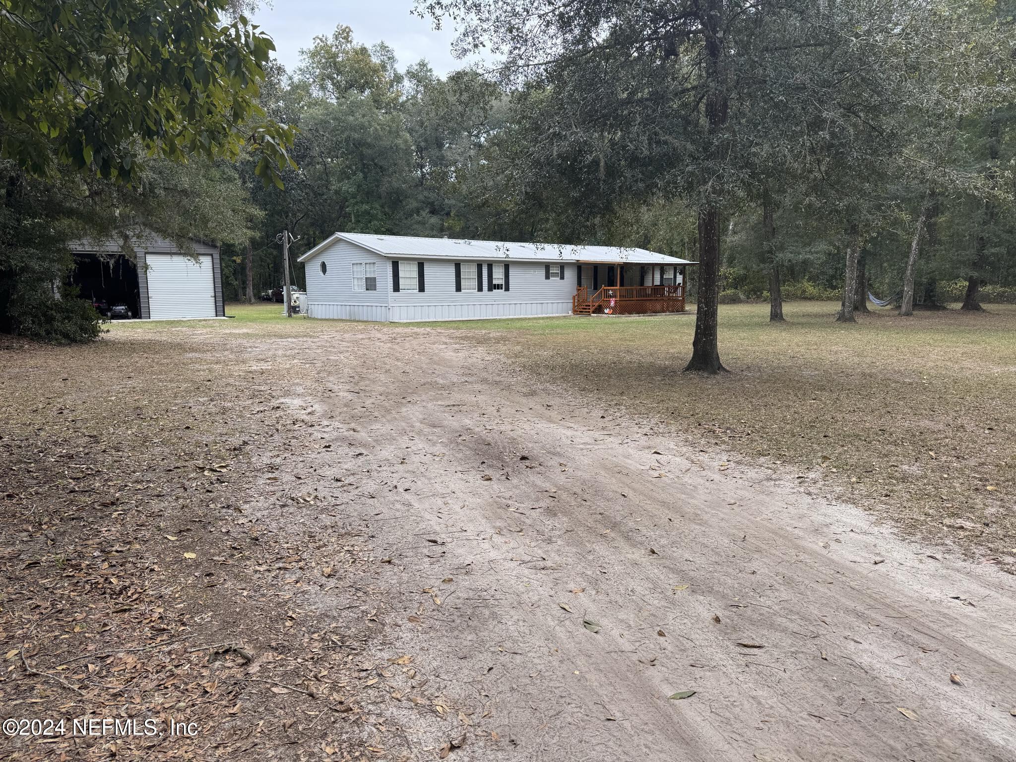 a front view of a house with large trees