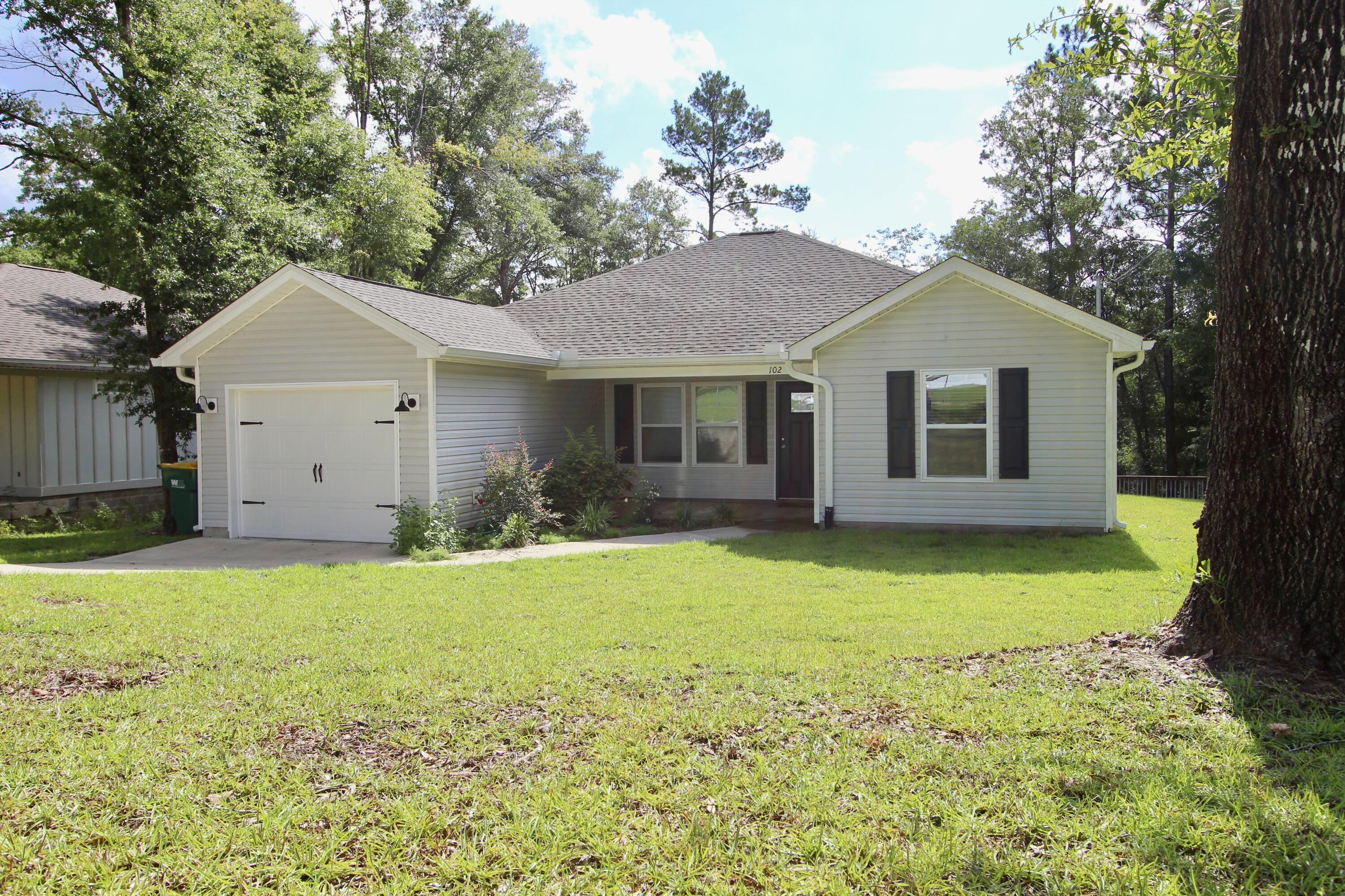 a front view of a house with yard and green space