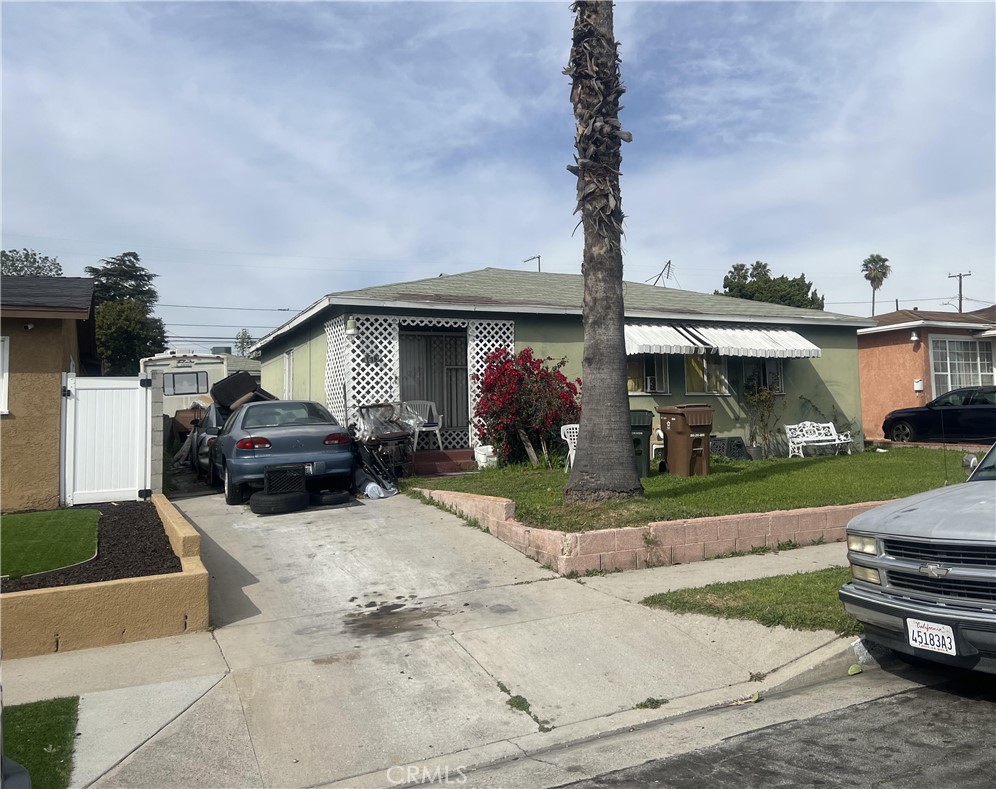 a front view of a house with a garden and parking space