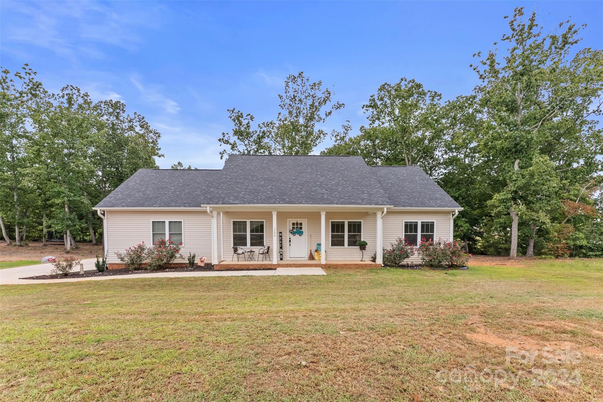 a front view of house with yard and trees around