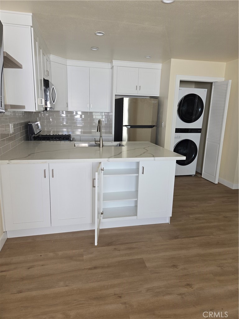 a kitchen with stainless steel appliances granite countertop a white stove top oven and a white cabinets