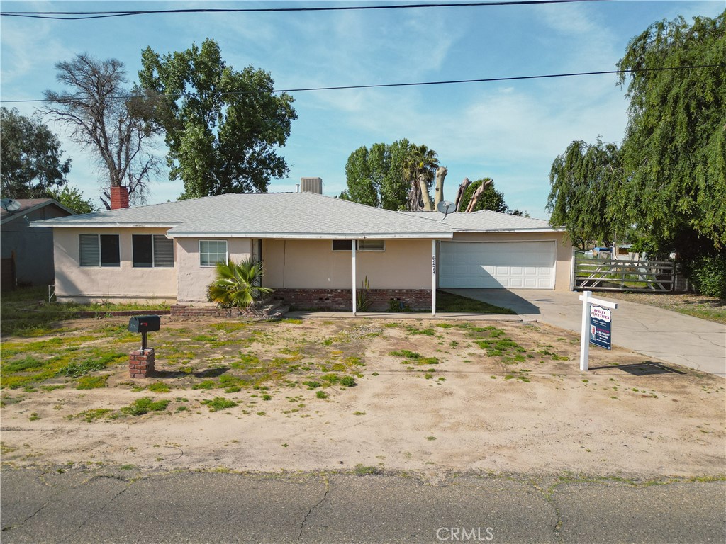 a view of a house with a yard and large tree