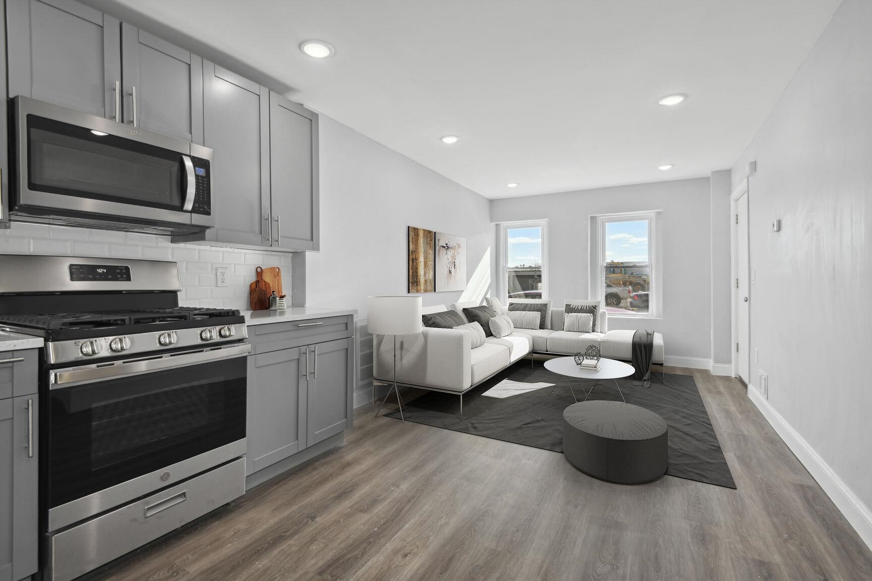 a living room with furniture a flat screen tv and kitchen view