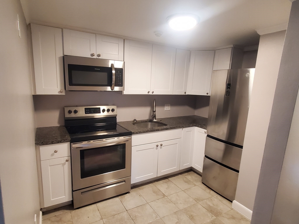 a kitchen with stainless steel appliances granite countertop a stove microwave and sink