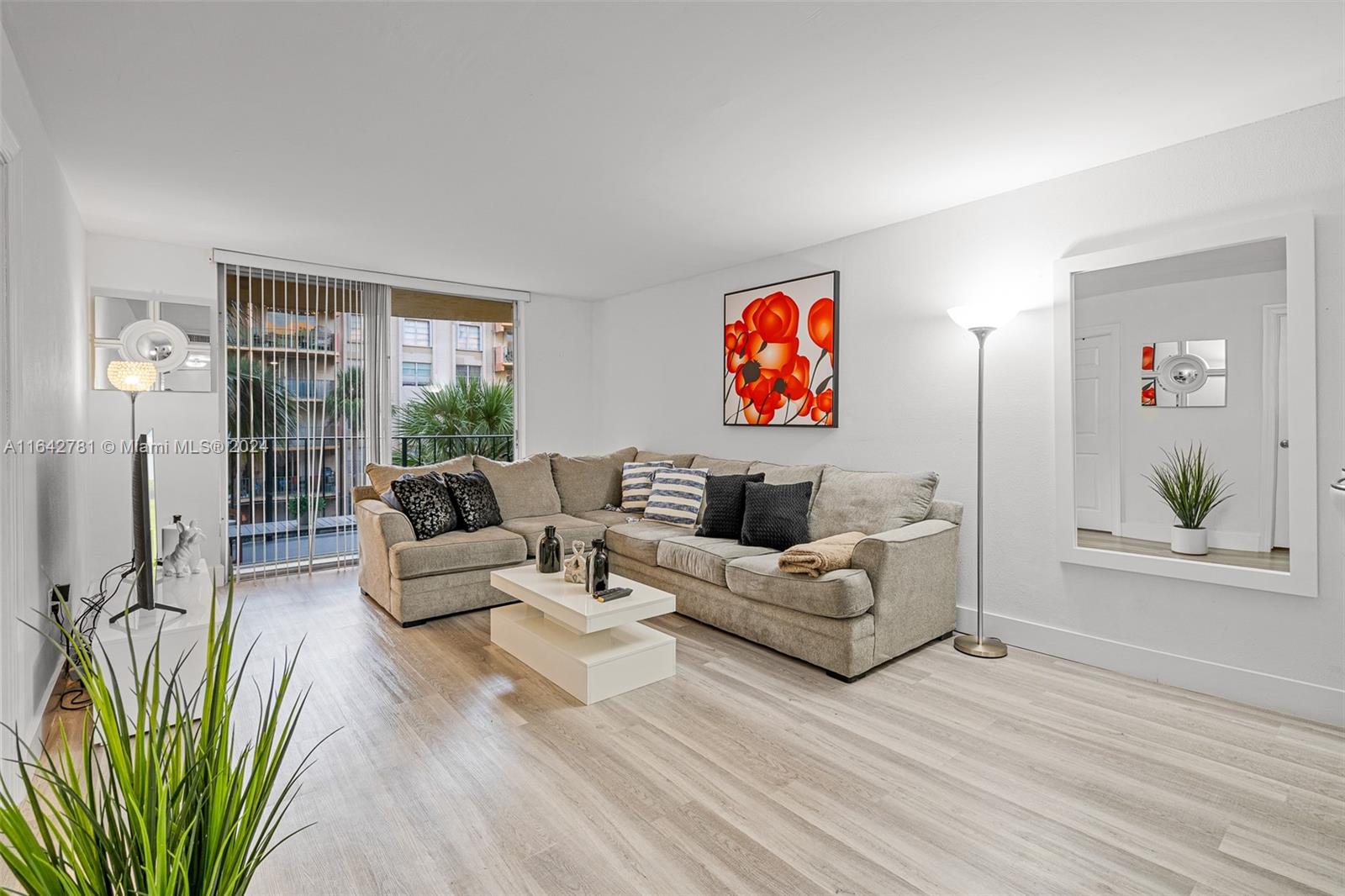 a living room with furniture a couch and a bookshelf with wooden floor