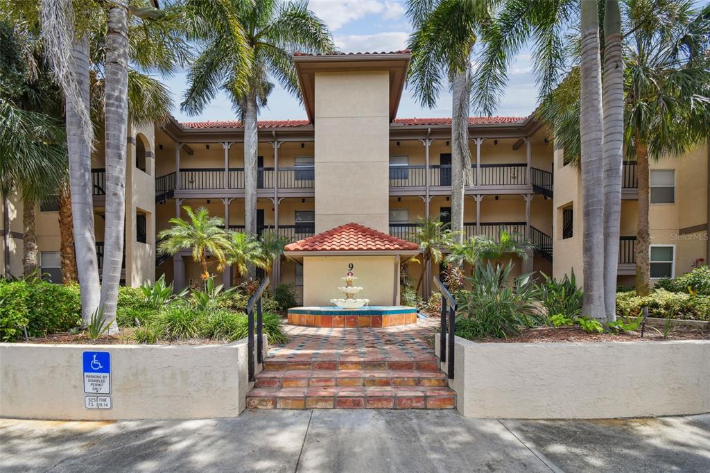 front view of a house with a yard and palm trees