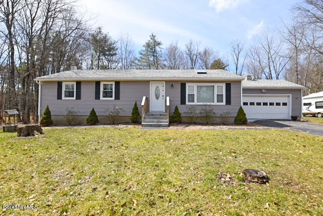 a front view of a house with a yard and trees