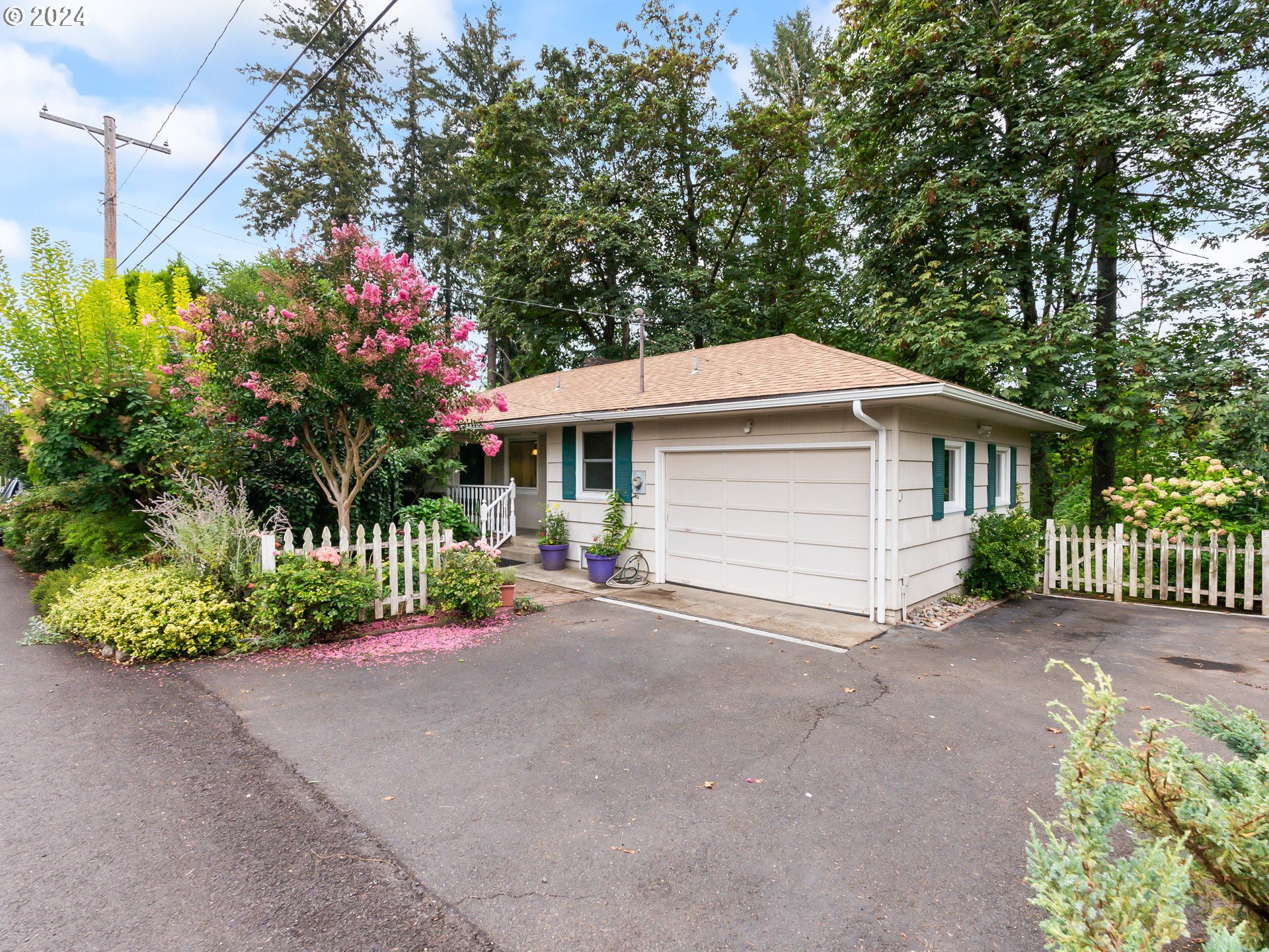 a front view of a house with a yard and potted plants