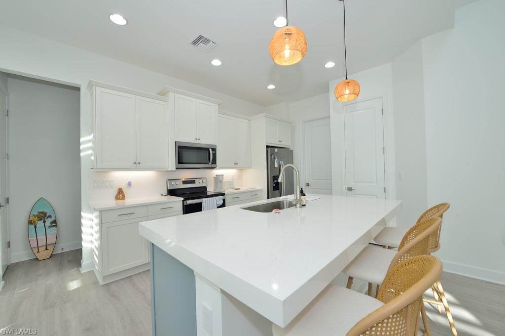 a kitchen with a table chairs a stove a microwave and cabinets