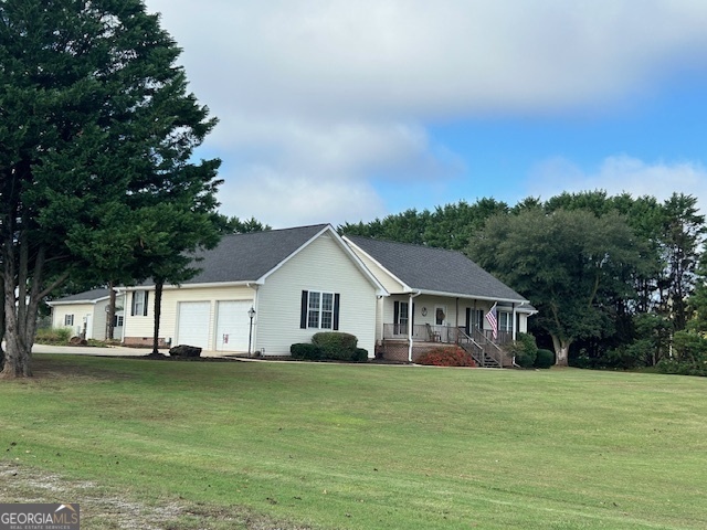 a front view of house with yard space and trees in the background