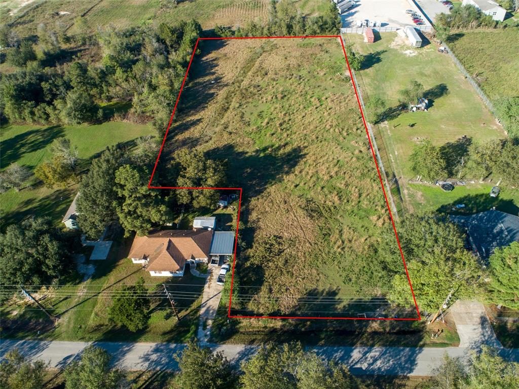 an aerial view of a house with a yard and large trees