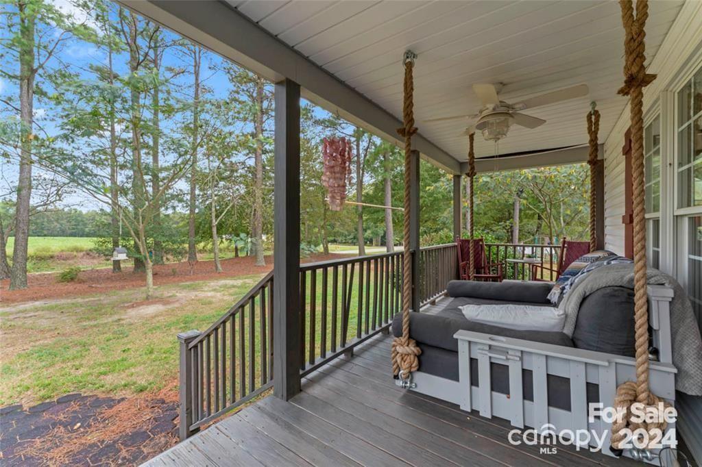 a view of a porch with furniture and a yard