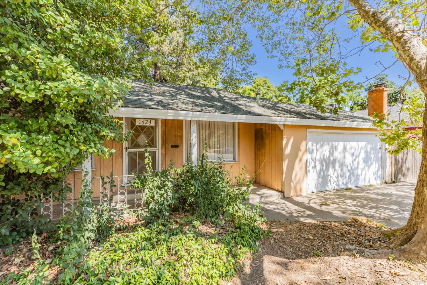 a front view of a house with a yard garage and outdoor seating