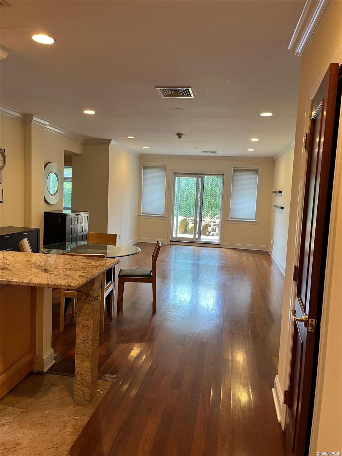 a open kitchen with stainless steel appliances granite countertop a stove refrigerator and wooden floor