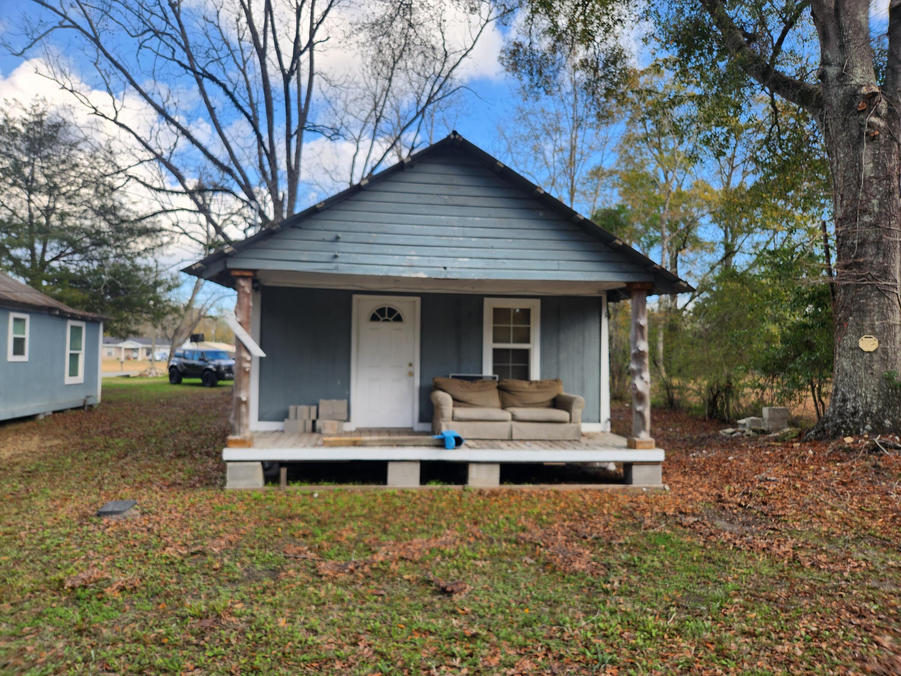 a front view of house with yard and trees in the background