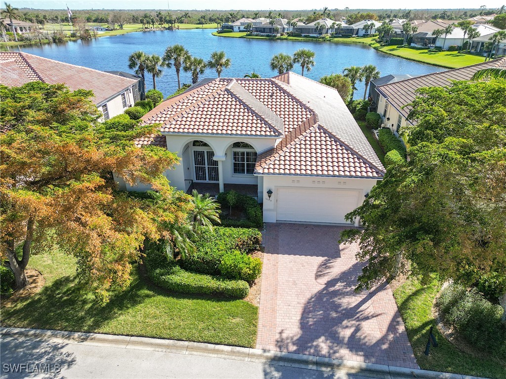 a front view of a house with a yard and lake view