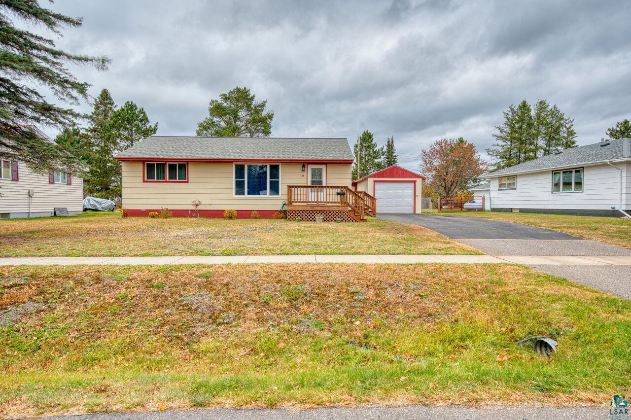 View of front of home featuring an outdoor structure, a front lawn, and a garage