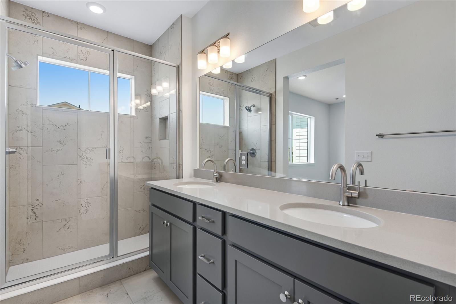 a bathroom with a granite countertop sink a large mirror and a shower