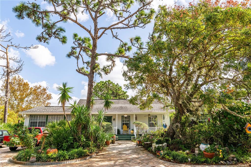 a front view of a house with a yard and tree s