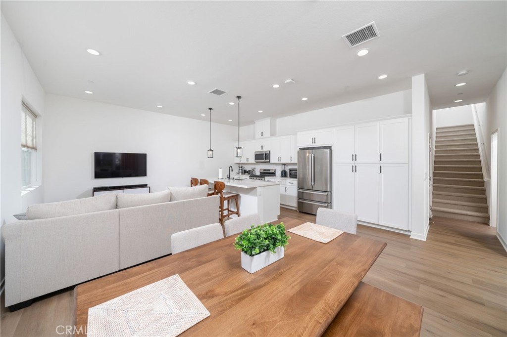 a kitchen with stainless steel appliances kitchen island granite countertop a refrigerator and a sink