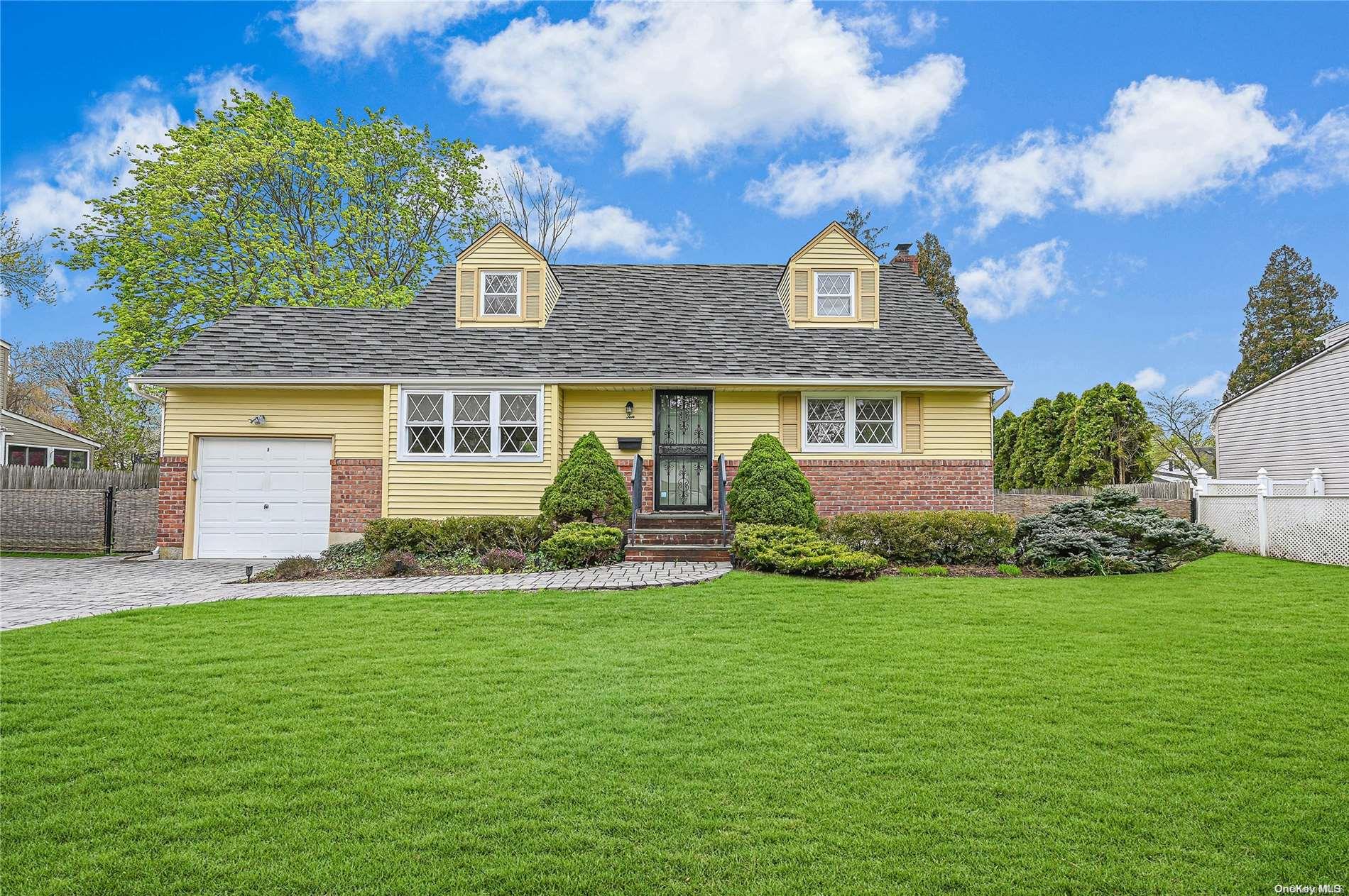 a front view of a house with a garden and yard