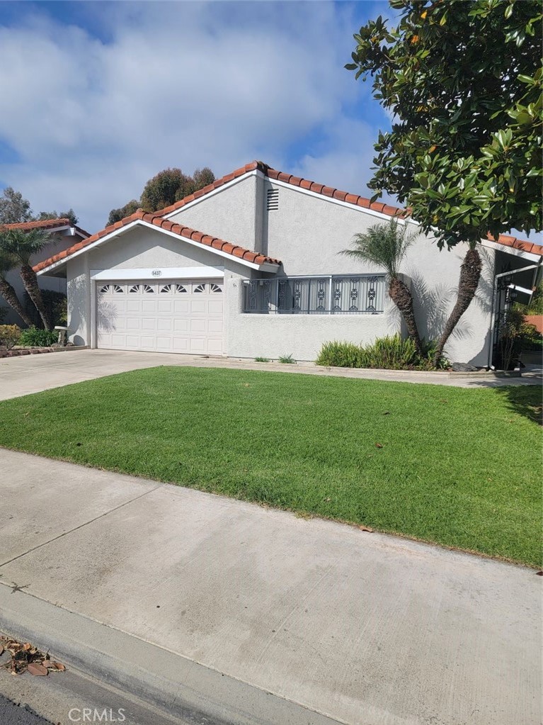 a view of a house with a yard and potted plants