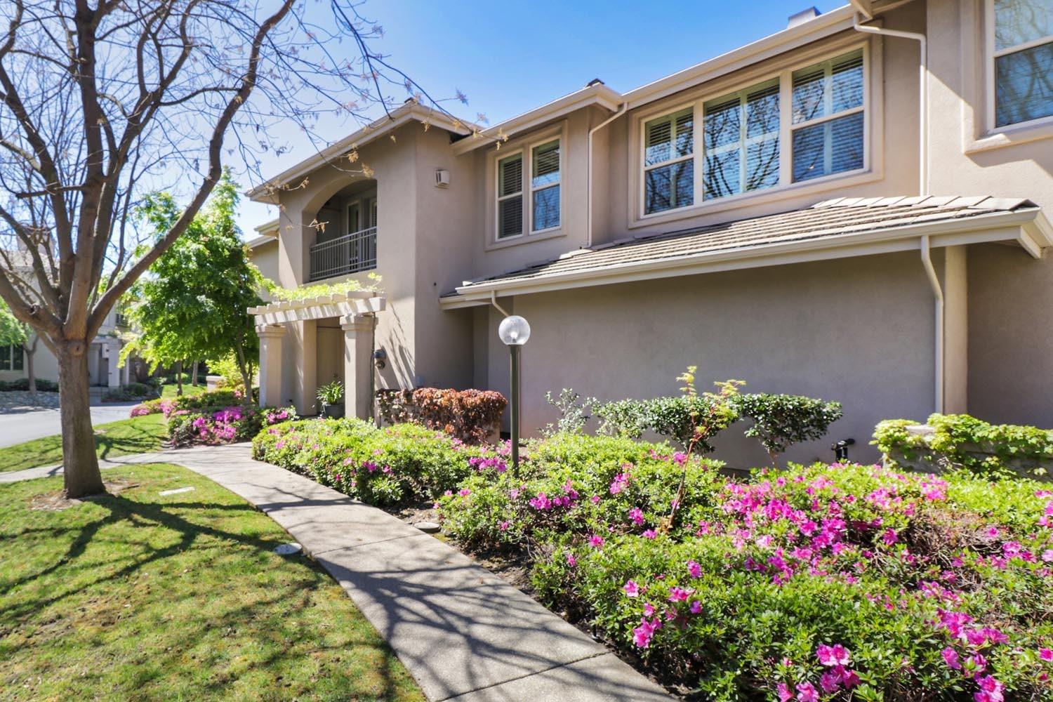 a front view of a house with a yard and fountain