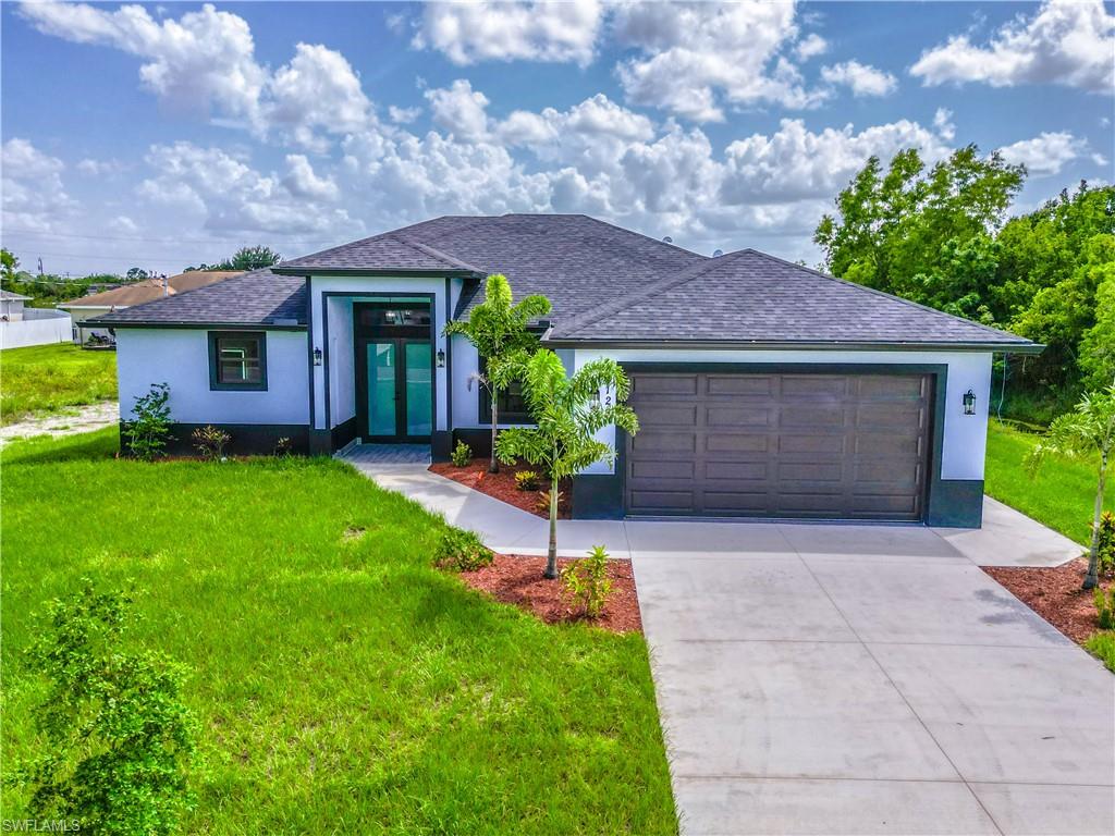 View of front of property featuring a garage and a front yard