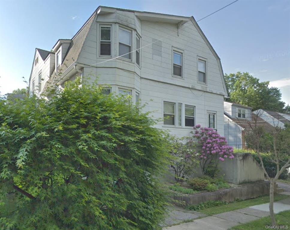 a front view of a house with plants