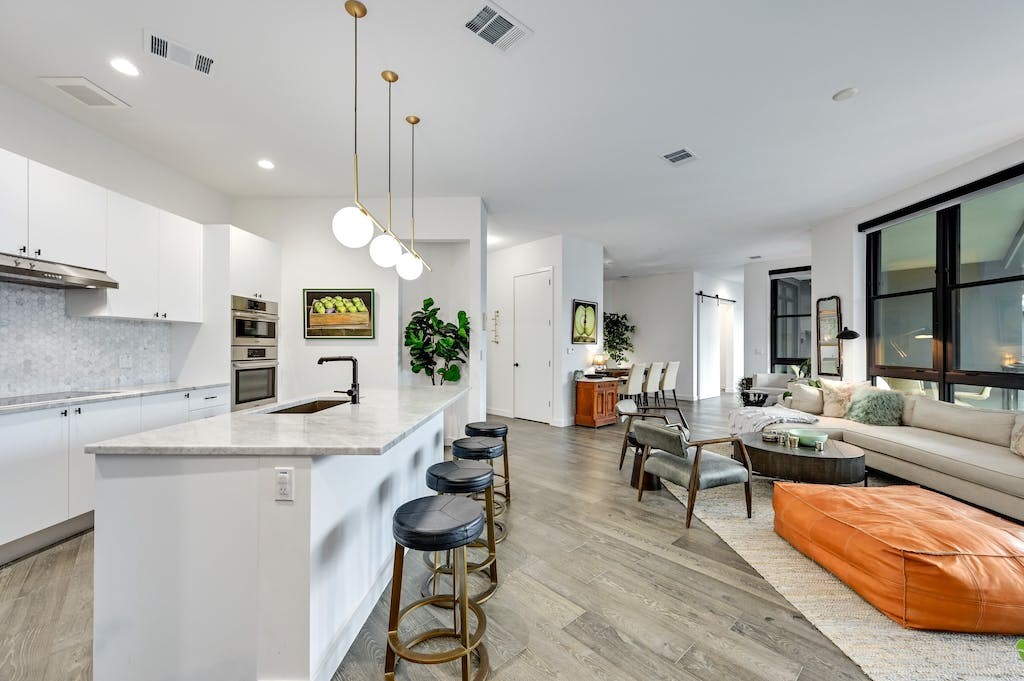 a living room with furniture kitchen view and a chandelier