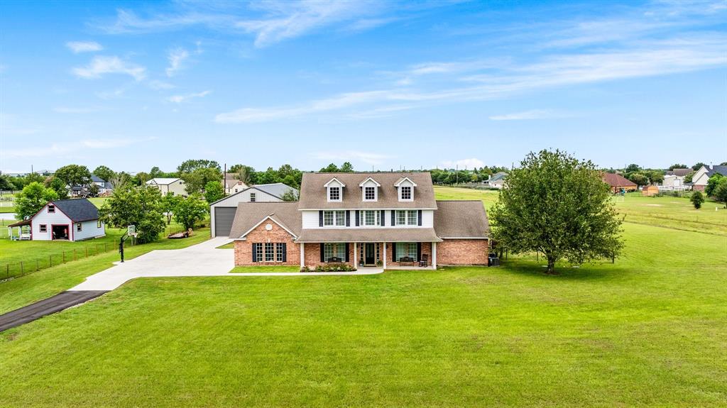 a aerial view of a house with a big yard and large trees