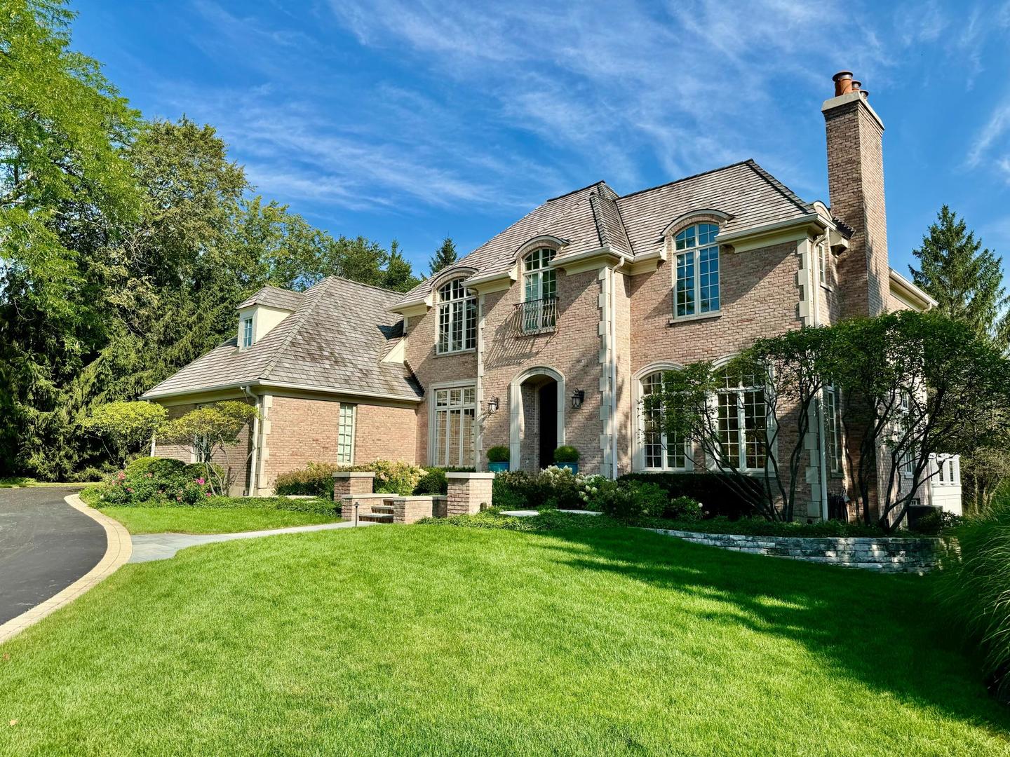 a view of a white house with a big yard and large trees