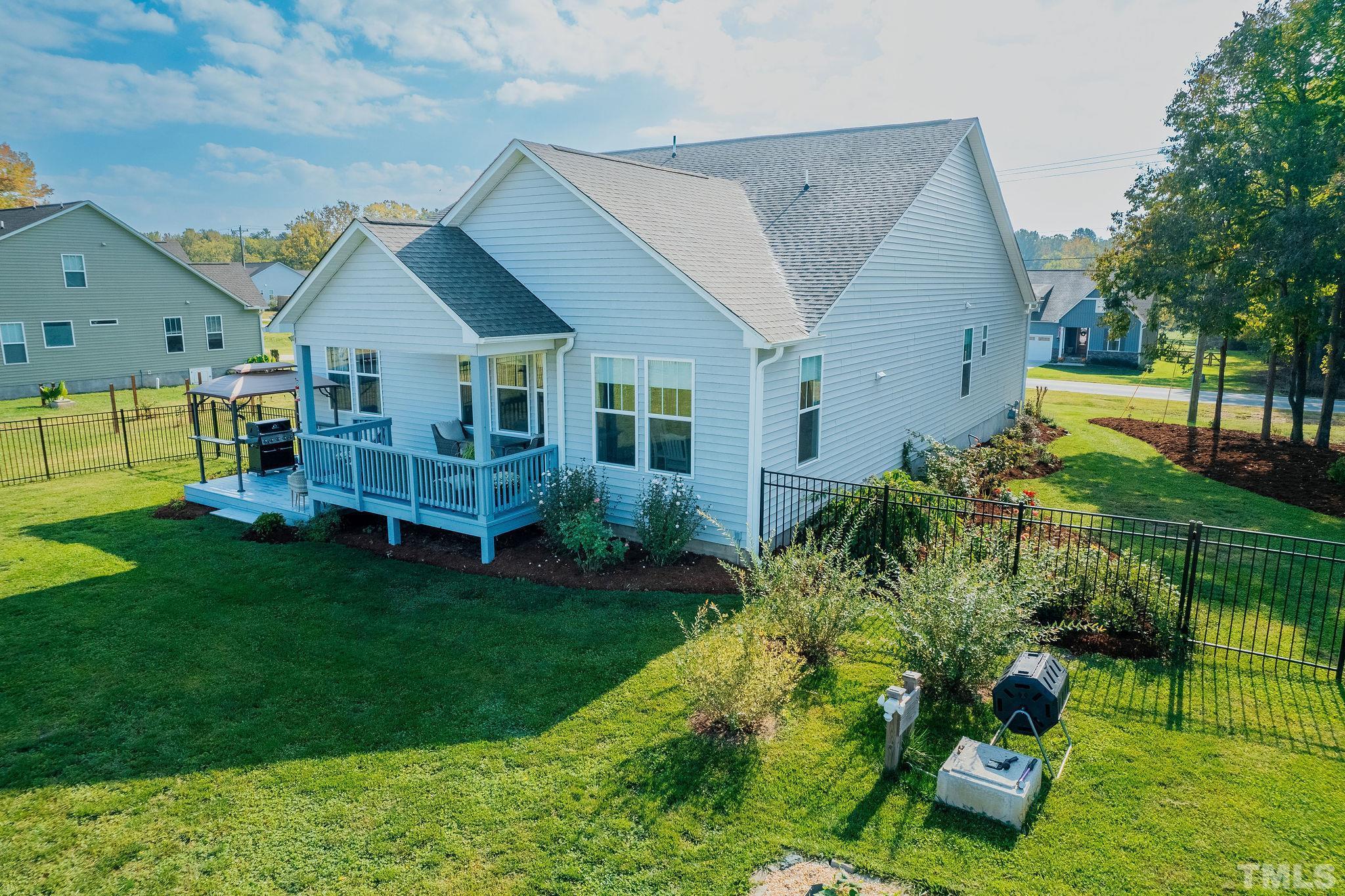 a aerial view of a house next to a big yard and large trees