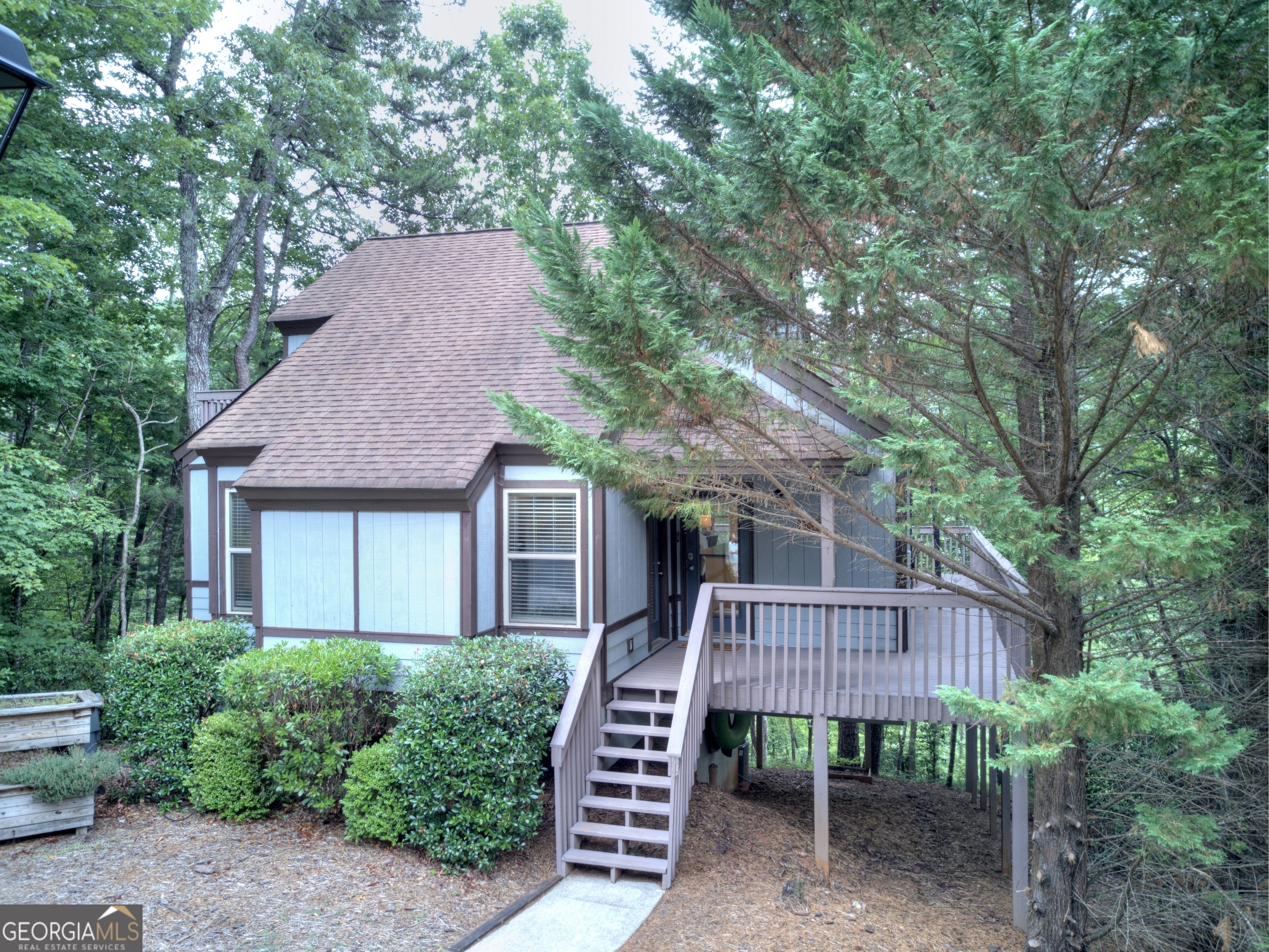 a view of a house with a roof deck and a large tree