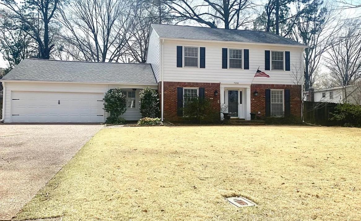 View of front of house with a garage and a front lawn