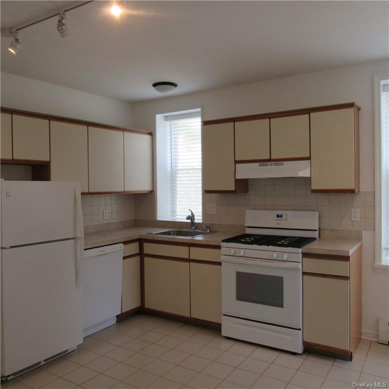 Kitchen featuring gas range, dishwasher, fridge an beautiful cabinets and countertops