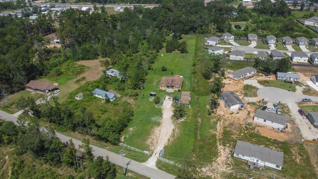 an aerial view of residential houses with outdoor space and trees