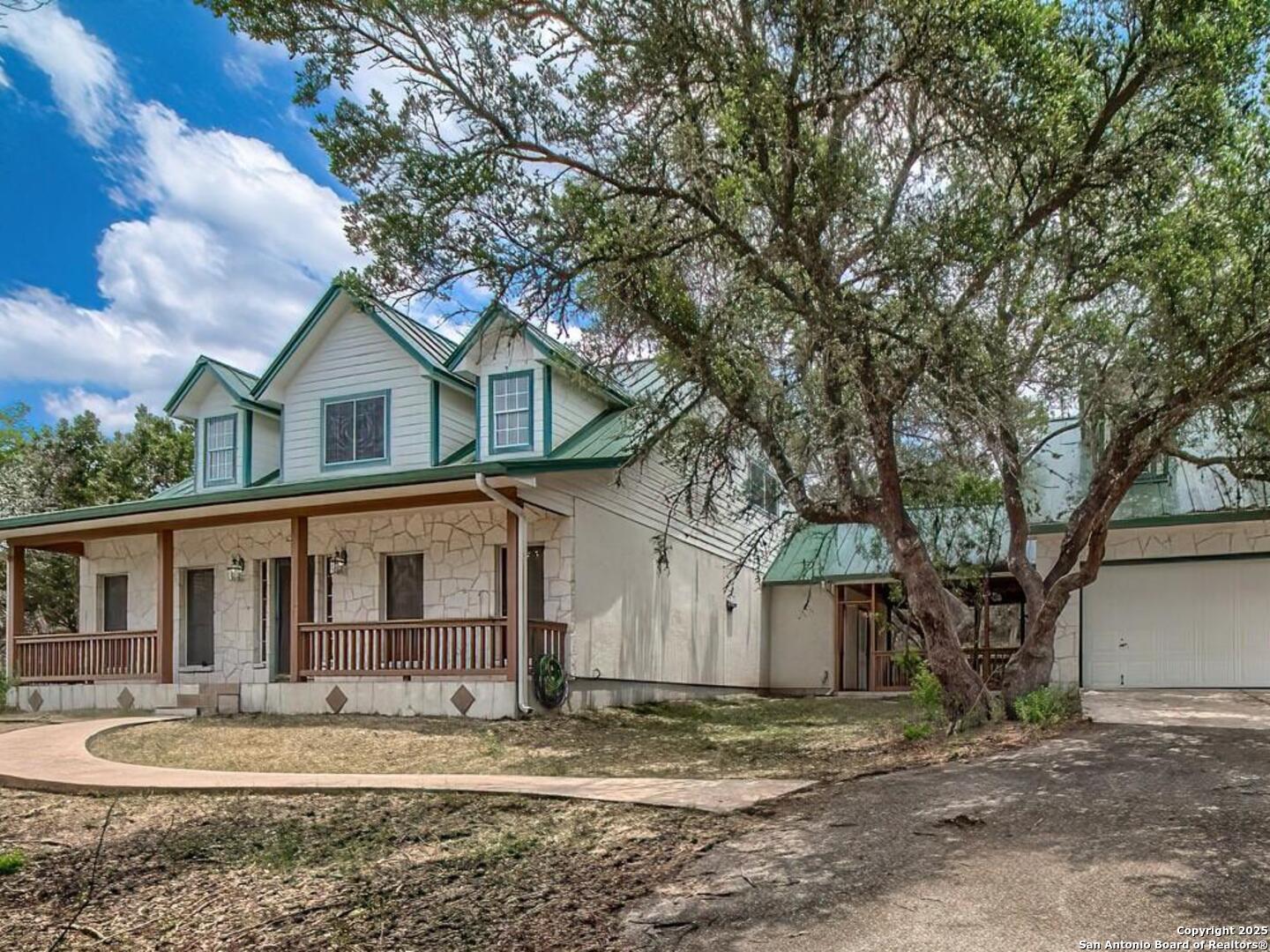 a front view of a house with a tree