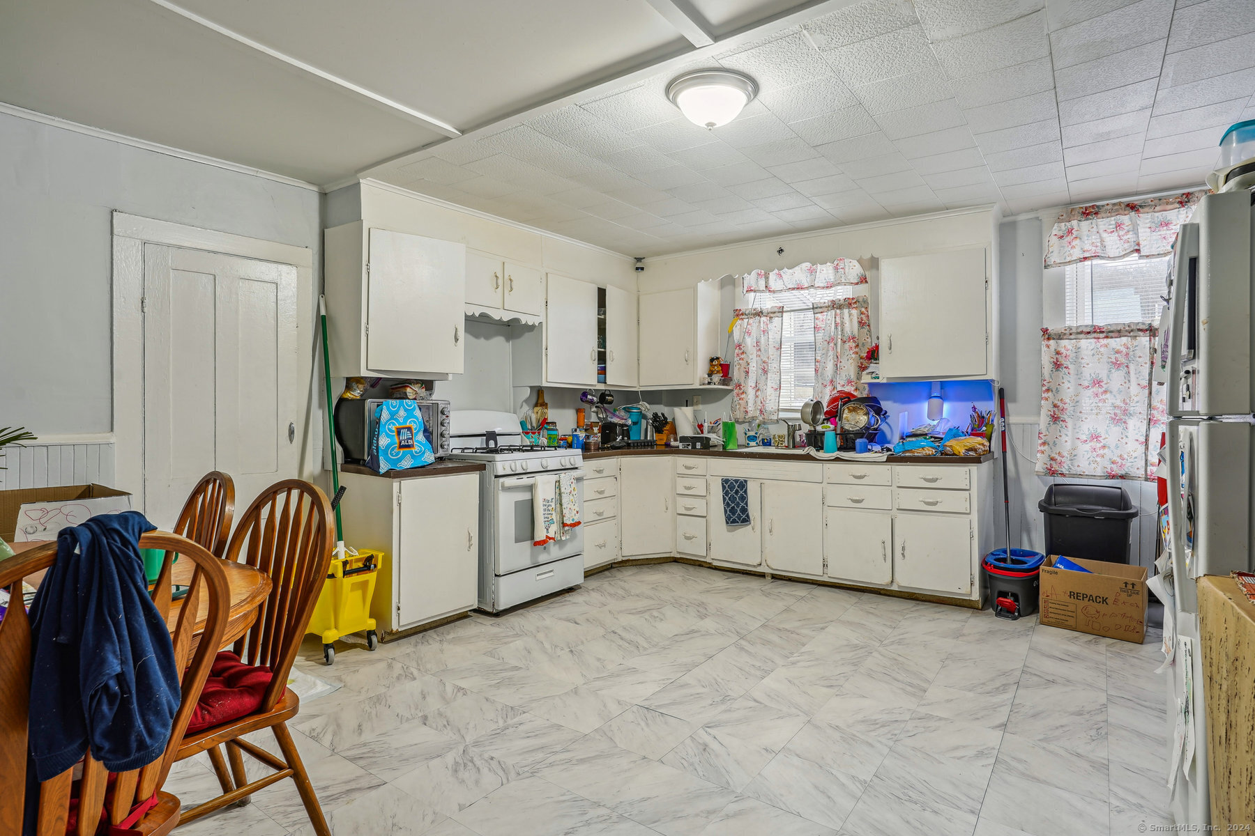 a kitchen with a refrigerator and white cabinets